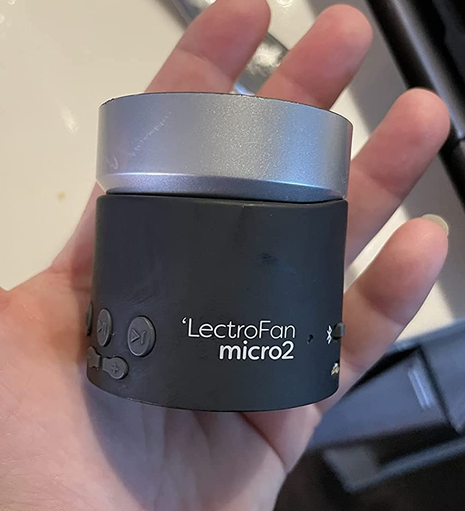 reviewer holding black sound machine