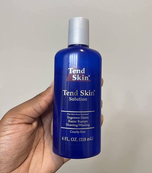 reviewer holding the bottle of tend skin solution