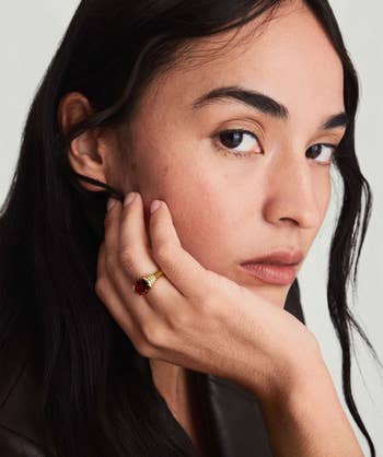 a model wearing a mejuri gold and garnet ring