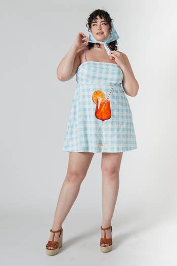 model in checkered dress with a large aperol spritz pictured