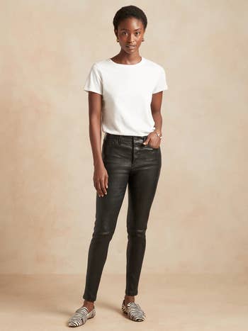 a model wearing black leather pants with a white t-shirt