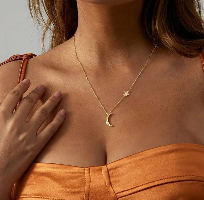  model wearing a gold moon and star necklace