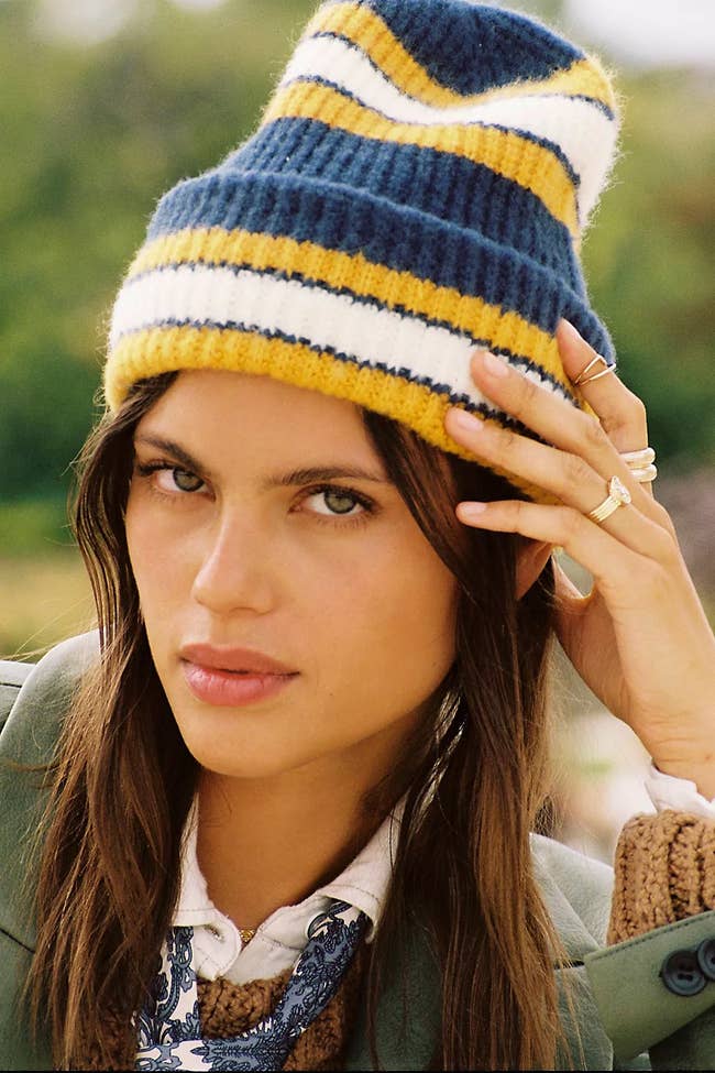 a model in a blue yellow and white striped beanie