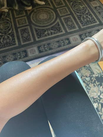 Reviewer with sunscreen sprayed connected limb showing lightweight and sheer formula