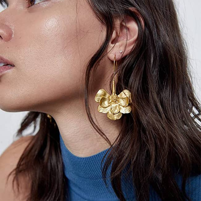 model with large floral earrings on 