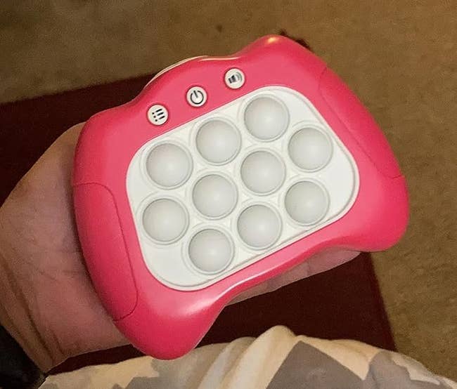 A reviewer holding the pink game