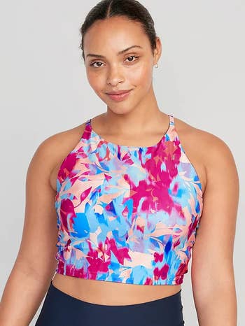Model in a longline sports bra with pink and blue flower pattern 