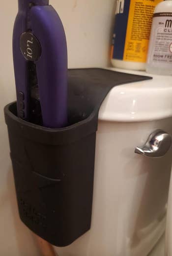 tool hanging from same holster slung on the side of a toilet 
