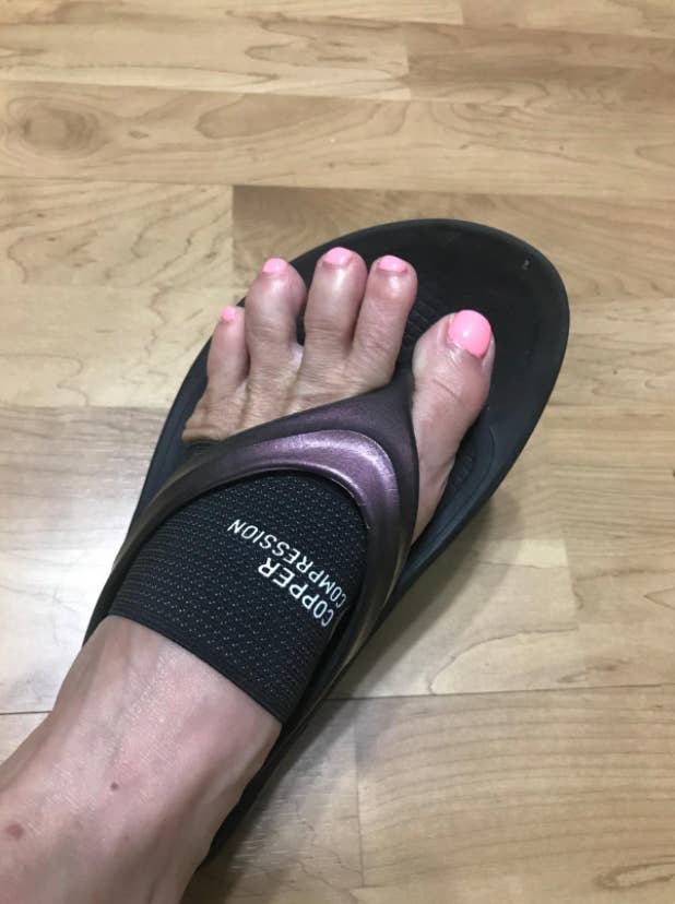 reviewer wearing the band on their foot and a flip-flop