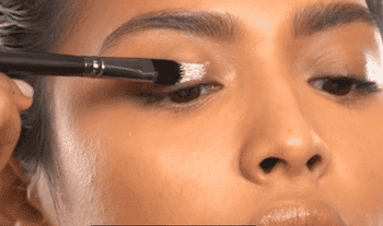 model applying a shimmery tint to their eyelid
