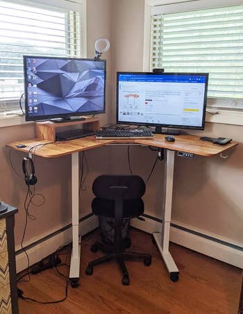 Home office setup with a standing desk, dual monitors, an ergonomic chair, and various desk accessories