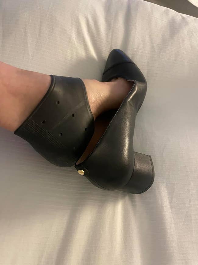 a reviewer wearing the black heel protector with a pair of heels