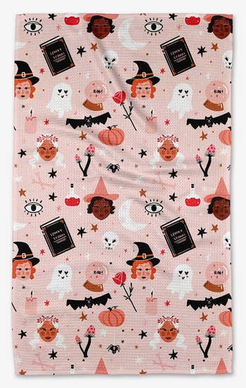 the pink tea towel with witches, ghosts, and more halloween designs on it