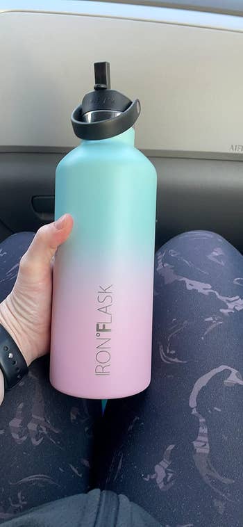 reviewer holding blue and pink ombre water bottle