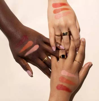 Multiple hands displaying various shades of the color corrector