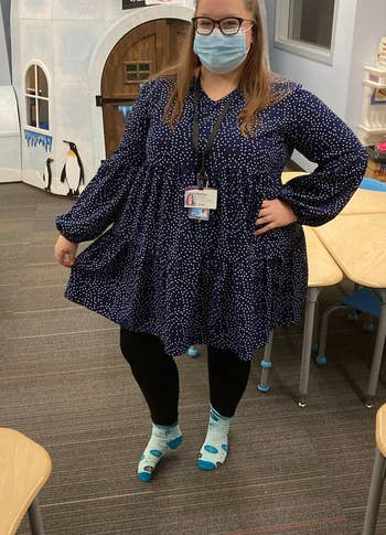 a reviewer wearing the long sleeve dress in navy blue with white polka dots 