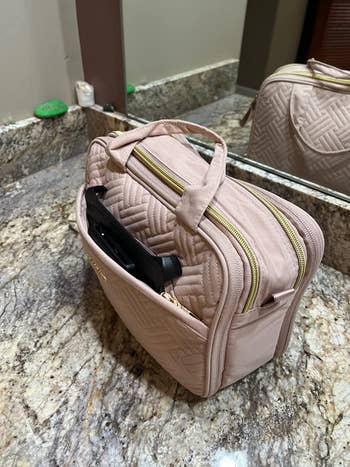 reviewer photo of beige cosmetics bag on bathroom counter