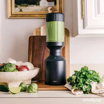 the black blender with a green smoothie in it