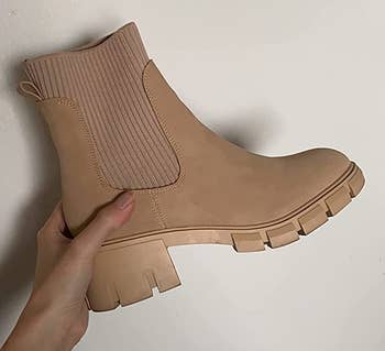 a reviewer holding the same boot in tan 