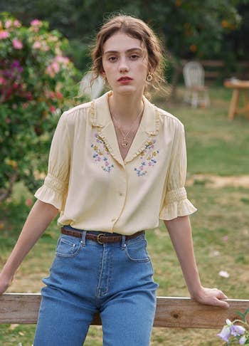 model outside wearing the yellow floral embroidered blouse