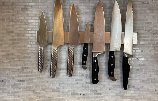 a reviewer photo of the magnetic knife bar mounted on a tile backsplash  