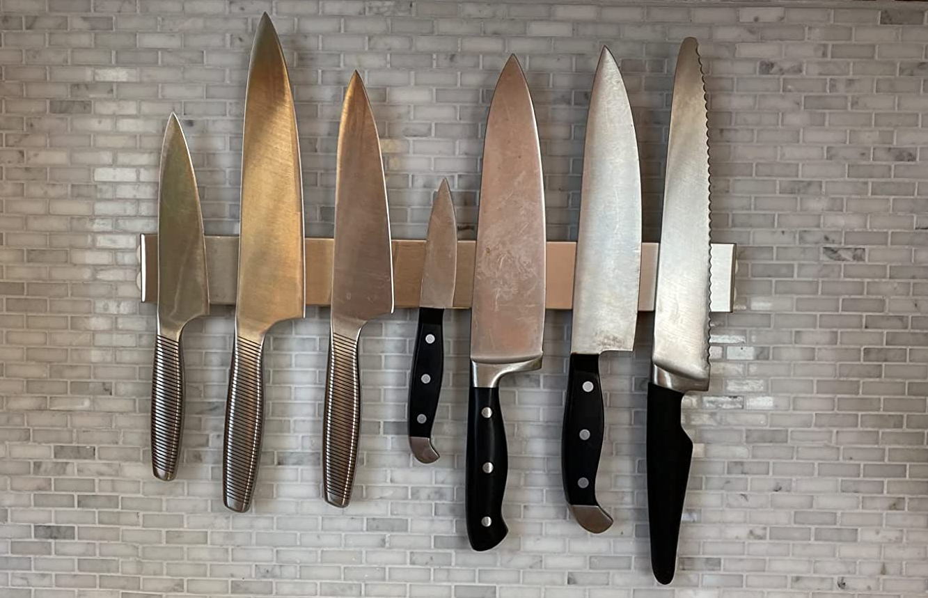 a reviewer photo of the magnetic knife bar mounted on a tile backsplash  