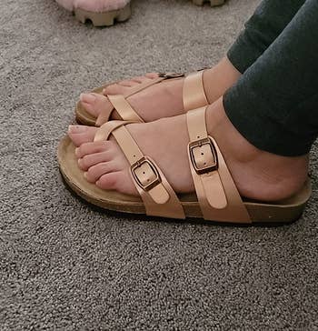reviewer wearing the sandals in rose gold