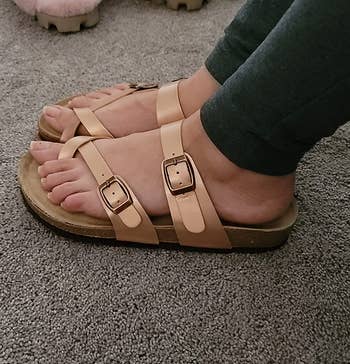 reviewer wearing the sandals in rose gold