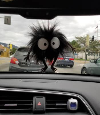 a reviewer photo of the sprite plushie hanging from a car rearview mirror 