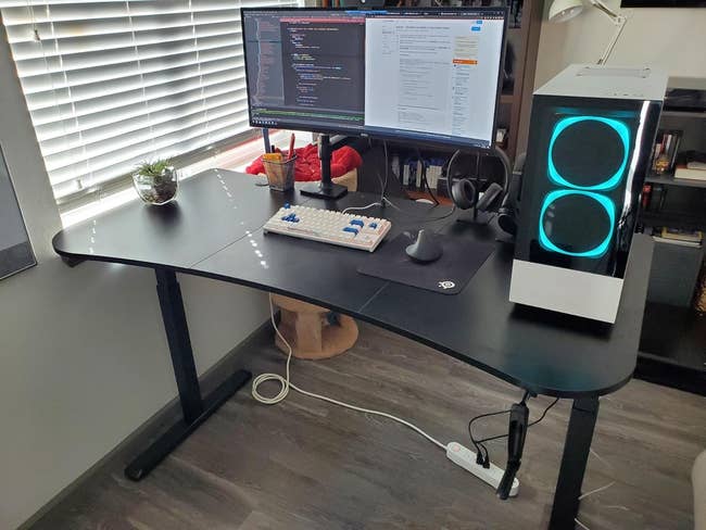 A well-organized desk with a computer setup, keyboard, monitor, and PC tower for a home office