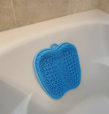Reviewer's foot scrubber placed on side of tub