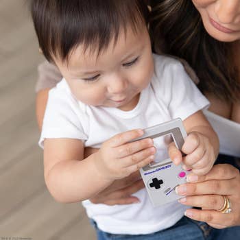 Woman and baby holding a classic handheld gaming device