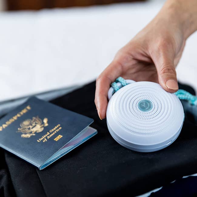 The portable white noise machine strapped to a suitcase