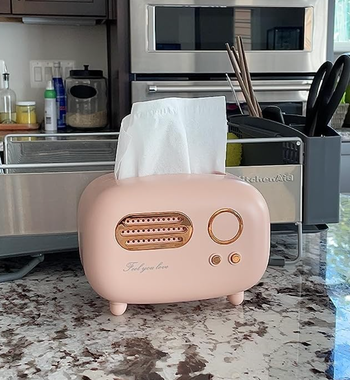 a small pink retro radio shaped box with a tissue sticking out 