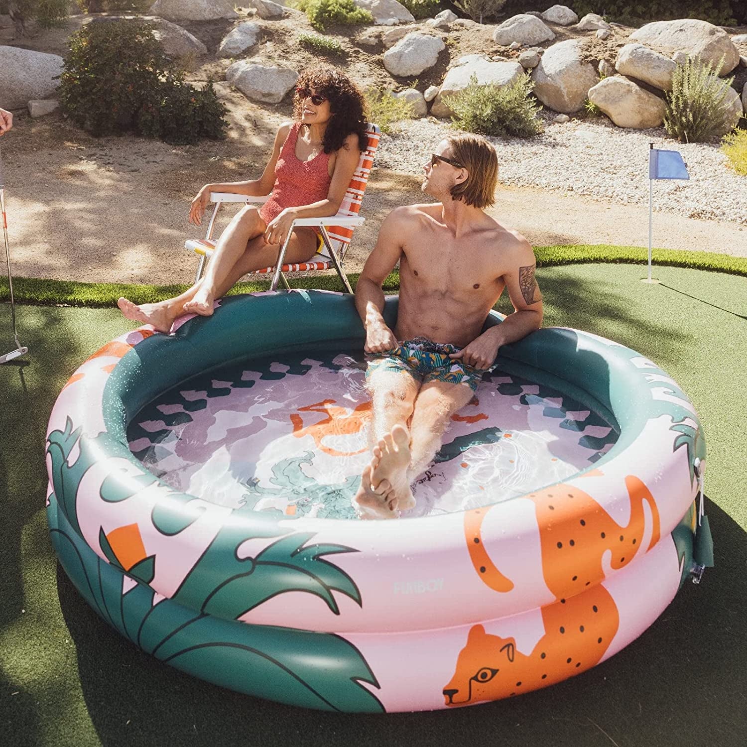 large kiddle pool with two models lounging in and around it
