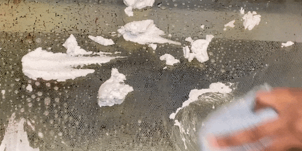 Gif of model using oven scrub on very dirty glass oven door and showing it come clean