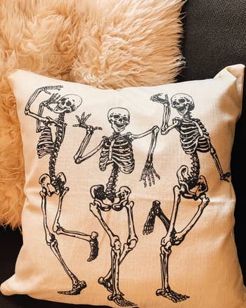 reviewer's close-up look at one of the throw pillows depicting dancing skeletons