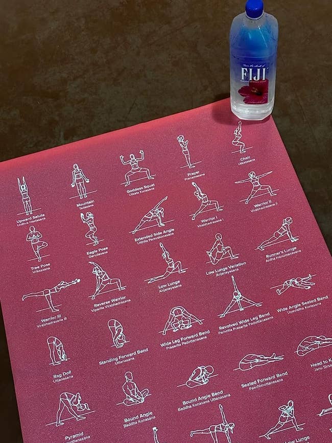 A top view of the yoga mat in pink with some of the printed positions