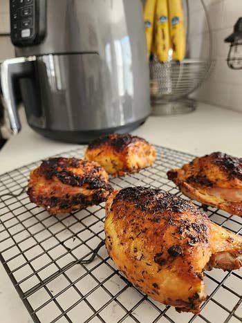 A reviewer's crispy chicken with the air fryer in the background