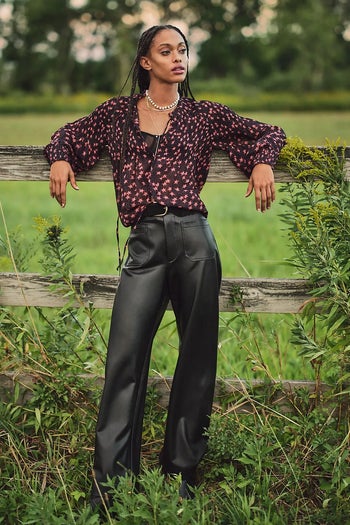 front of model wearing the black pants with a floral long sleeve top