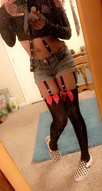 reviewer mirror selfie wearing the garter belt with thigh-high stockings and bows