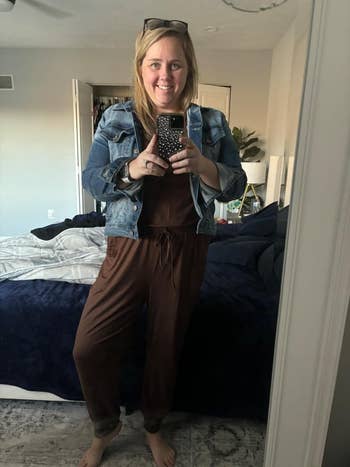 Person takes a reflector  selfie wearing a casual outfit with a denim overgarment   and brownish  jumpsuit, lasting  successful  a chamber  setting
