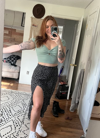 a reviewer wearing the skirt in black with a white dotted print 