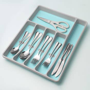 a silverware organizer with teal blue lining