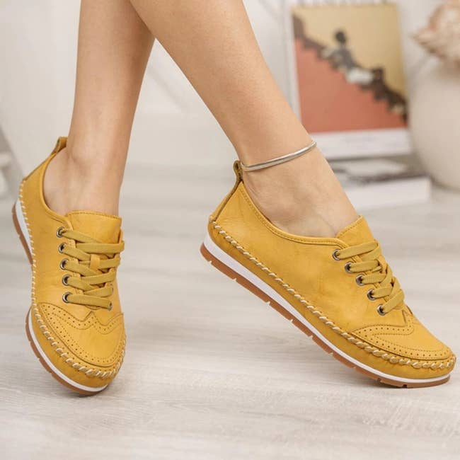 a pair of yellow leather sneakers