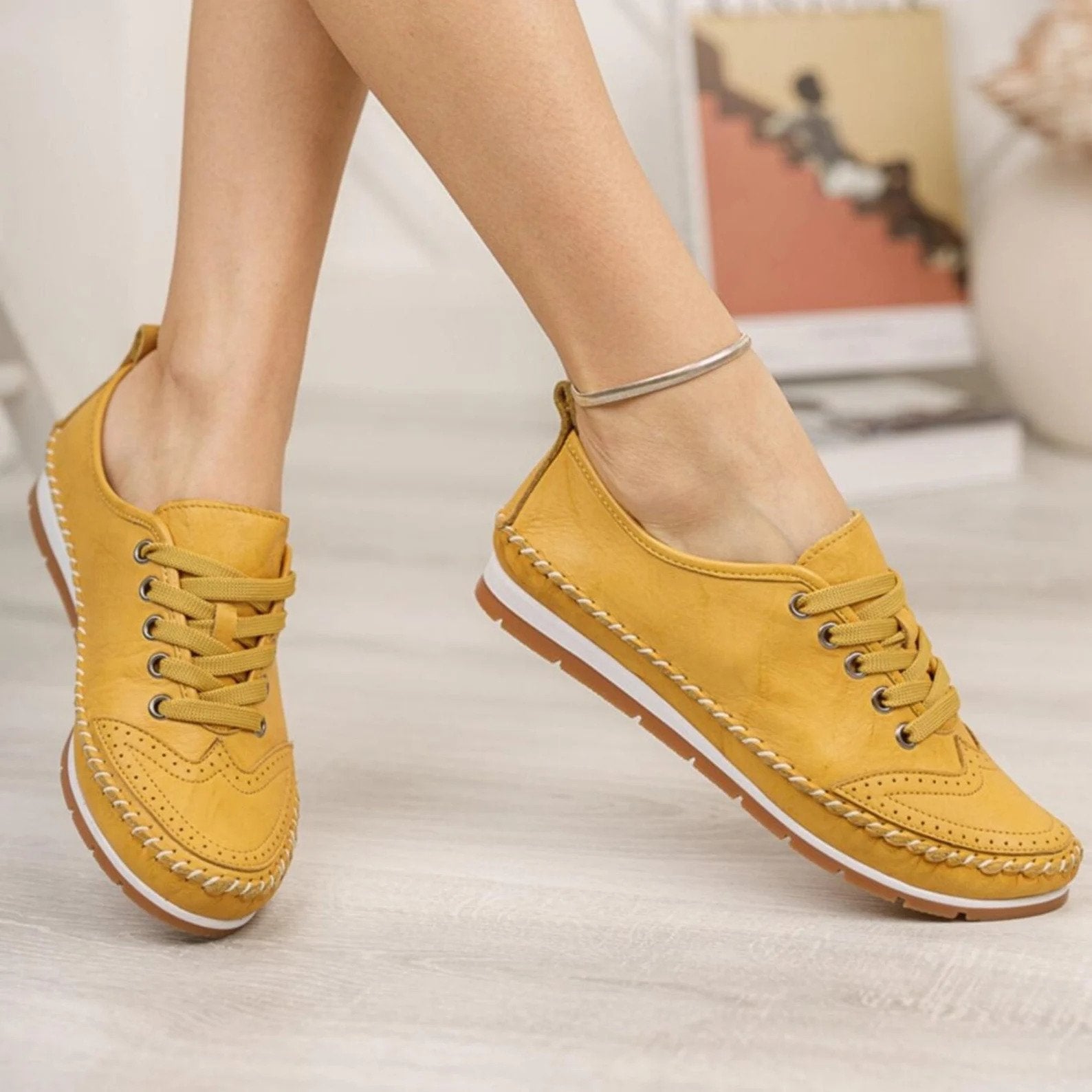 a pair of yellow leather sneakers
