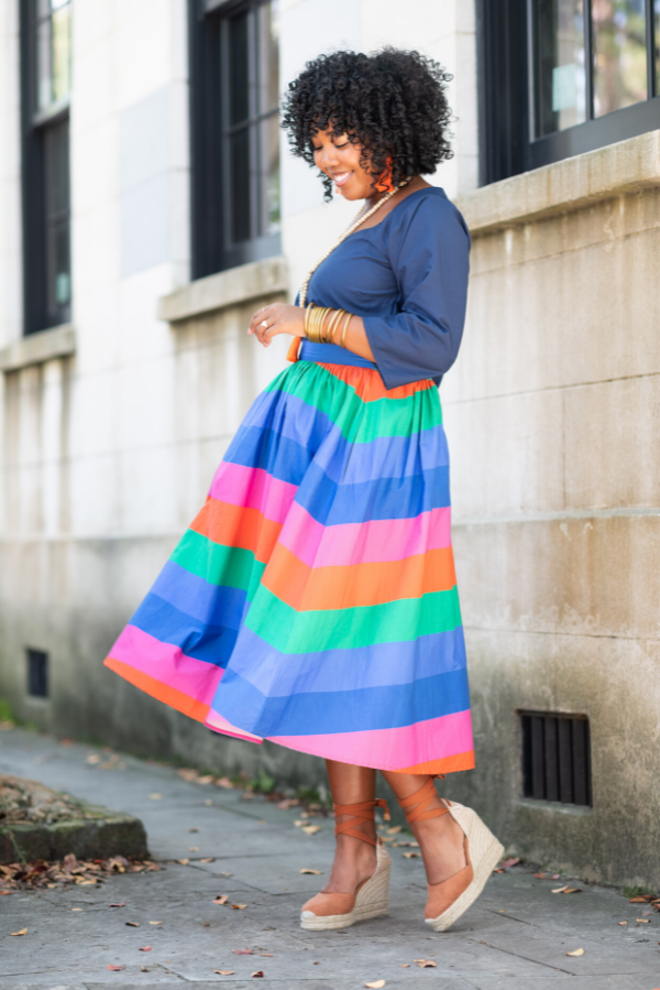 business owner twirling in colorful skirt