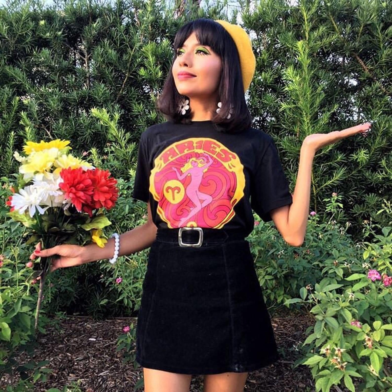 model wearing black t-shirt with a vibrant, 70s-style