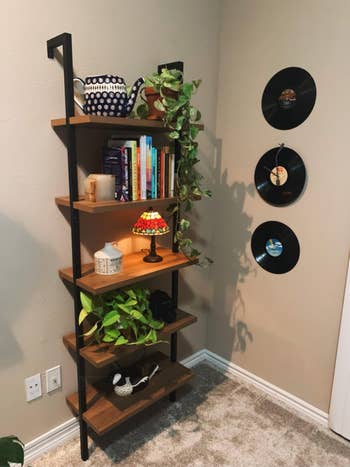 another reviewers oak and achromatic 5-tier support holding assorted plants, books, and knickknacks