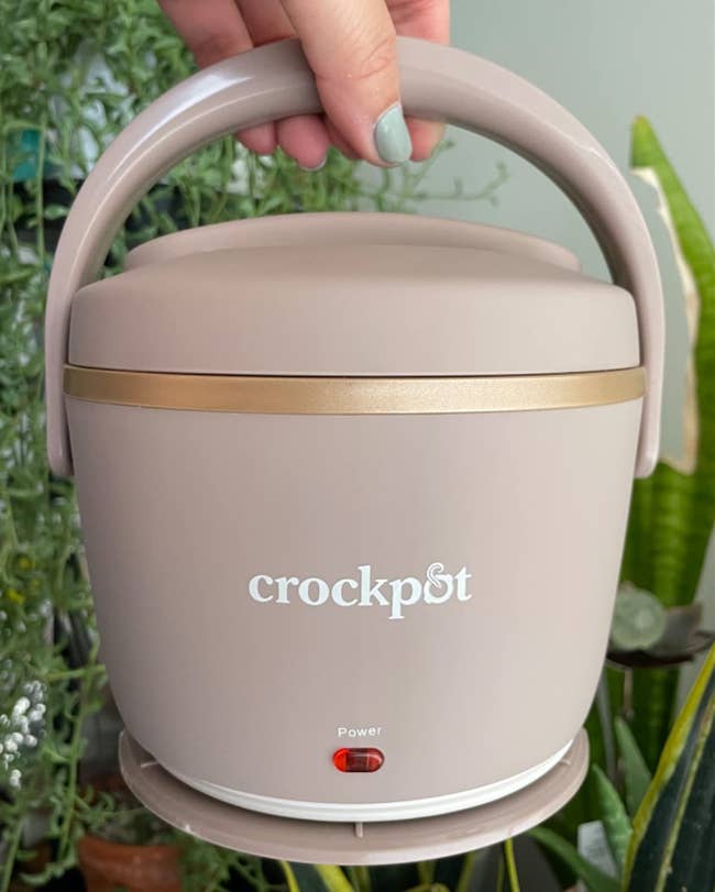 image of reviewer holding up the blush pink portable crock pot